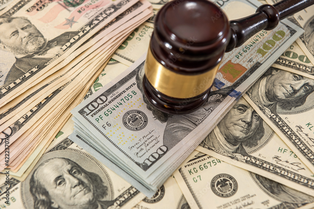 Wooden judge gavel and us money dollar bills
